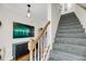 Carpeted staircase with wood railing, complemented by artwork, a cabinet and lots of light at 118 Congress St # F, Charleston, SC 29403