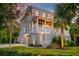 Charming home with a well-maintained lawn, large palm trees, and inviting front porch with white railing and brick facade at 1212 Clonmel Pl, Mount Pleasant, SC 29464