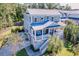 Stunning coastal home features a metal roof, shutters, and a welcoming front porch with stairs leading to a lush yard at 1212 Clonmel Pl, Mount Pleasant, SC 29464