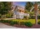 Inviting two-story home with lush lawn, mature palm trees, and a welcoming front porch with classic white railing and facade at 1212 Clonmel Pl, Mount Pleasant, SC 29464