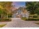 Beautiful home featuring a brick paver driveway, two car garage, complemented by meticulously landscaped yard, and exterior lighting at 1212 Clonmel Pl, Mount Pleasant, SC 29464