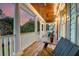 Inviting front porch with classic white columns and wood floors, complete with outdoor seating, perfect for relaxing at 1212 Clonmel Pl, Mount Pleasant, SC 29464