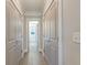 Bright hallway featuring hardwood floors, recessed lighting, and storage closets leading to a bathroom at 1212 Clonmel Pl, Mount Pleasant, SC 29464