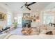 Bright living room boasts a stone fireplace, ceiling fan, and hardwood floors, creating a welcoming and stylish space at 1212 Clonmel Pl, Mount Pleasant, SC 29464