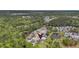 An aerial view of a community shows a green home with solar panels near a pond and tree line at 123 Mcdonald Ct, Summerville, SC 29485
