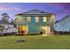 Back exterior featuring a well-maintained yard, solar panels, patio, and fire pit area at 123 Mcdonald Ct, Summerville, SC 29485