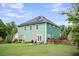 Back exterior showcasing solar panels, a spacious yard, patio, and mature landscaping at 123 Mcdonald Ct, Summerville, SC 29485