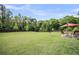Expansive backyard with a lush lawn, patio area, and scenic tree line, great for outdoor activities at 123 Mcdonald Ct, Summerville, SC 29485