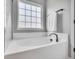 A white soaking tub in a neutral bathroom near a window lets natural light in at 123 Mcdonald Ct, Summerville, SC 29485