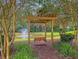 Picturesque community with a wooden swing by the pond and fountain, surrounded by trees at 123 Mcdonald Ct, Summerville, SC 29485