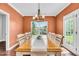 Elegant dining room featuring a long table, stylish chandelier, and large window offering scenic outdoor views at 123 Mcdonald Ct, Summerville, SC 29485