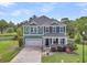 Beautiful green two-story home featuring an attached two-car garage and covered front porch at 123 Mcdonald Ct, Summerville, SC 29485