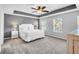 A gray main bedroom featuring tray ceilings, a ceiling fan, neutral decor, and bright windows at 123 Mcdonald Ct, Summerville, SC 29485