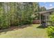 A backyard view showcasing a lush, green lawn and a privacy fence bordering the wooded area at 134 Longford Dr, Summerville, SC 29483
