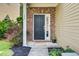 Inviting front door with brick surround, adjacent to the covered porch and manicured landscaping at 134 Longford Dr, Summerville, SC 29483