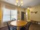 Charming dining area with a wooden table and seating for four, complemented by an elegant chandelier and natural light at 139 Pointer Dr, Goose Creek, SC 29445