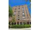 Large brick condo building with multiple stories and windows with a lush green landscape at 14 Lockwood Dr # 2E, Charleston, SC 29401