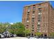 Exterior of tall brick condo building, with landscape and several parked cars on a sunny day at 14 Lockwood Dr # 2E, Charleston, SC 29401