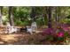 Backyard lounge area featuring two white adirondack chairs and a fire pit surrounded by blooming flowers at 1470 Eutaw Battalion Dr, Charleston, SC 29412
