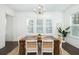 Elegant dining room featuring a rustic wooden table, modern chandelier, and bright natural light through large windows at 1470 Eutaw Battalion Dr, Charleston, SC 29412