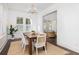 Bright dining room with a dark wood table, woven chairs, jute rug and chandelier at 1470 Eutaw Battalion Dr, Charleston, SC 29412