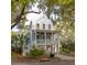 Charming two-story home with a welcoming front porch, lush landscaping, and mature trees at 1470 Eutaw Battalion Dr, Charleston, SC 29412
