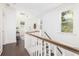 Upstairs hallway with dark wood floors and white trim, with a seating area visible at the end at 1470 Eutaw Battalion Dr, Charleston, SC 29412