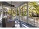 Relaxing porch with comfortable seating and a ceiling fan, offering scenic neighborhood views surrounded by lush trees at 1470 Eutaw Battalion Dr, Charleston, SC 29412