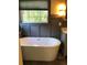 Bathroom featuring a freestanding tub, wainscoting, and a view to the outside at 1496 Cypress Pointe Dr, Mount Pleasant, SC 29466
