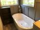 Modern bathroom featuring a freestanding tub, wainscoting, and a view to the outside at 1496 Cypress Pointe Dr, Mount Pleasant, SC 29466