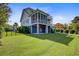View of the lush backyard and exterior showing multiple levels of covered outdoor living space at 1500 Bower Ln, Johns Island, SC 29455