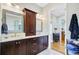 Bathroom featuring double sinks, granite counters, dark wood cabinetry, and an adjacent view into a bedroom at 1500 Bower Ln, Johns Island, SC 29455