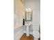 Charming powder room featuring a pedestal sink, decorative mirror, and natural light from a window at 1500 Bower Ln, Johns Island, SC 29455
