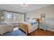 Bedroom with hardwood floors, view of waterfront from a large window, and a blue and white quilt on the bed at 1500 Bower Ln, Johns Island, SC 29455