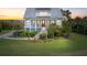 Charming two-story home with a covered porch, a metal roof, solar panels, and well-maintained landscaping at 1500 Bower Ln, Johns Island, SC 29455