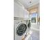 Bright laundry room with modern washer and dryer, storage cabinets and a window at 1500 Bower Ln, Johns Island, SC 29455
