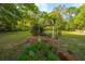 Landscaped backyard features a charming bench swing, lush foliage, and garden accents at 1518 Southwick Dr, Johns Island, SC 29455