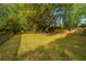 Expansive backyard featuring a wooden fence, mature trees, and a charming treehouse at 1518 Southwick Dr, Johns Island, SC 29455