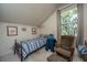 Traditional-style bedroom with a cozy armchair, a striped bedspread, and natural light from the window at 1518 Southwick Dr, Johns Island, SC 29455