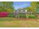 Charming two-story home with a screened-in porch and beautifully landscaped front yard with colorful flowers at 1518 Southwick Dr, Johns Island, SC 29455