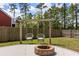 Inviting backyard with a fire pit, swing chairs, wooden fence, and lush green lawn at 153 Lucca Dr, Summerville, SC 29486