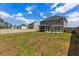 Expansive backyard with a large lawn, patio area, swing chairs, and privacy fence at 153 Lucca Dr, Summerville, SC 29486