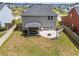 Aerial view of a backyard featuring a covered patio, fire pit, and lush lawn, enclosed by a wooden fence at 153 Lucca Dr, Summerville, SC 29486