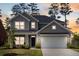 Inviting home featuring a two-car garage, covered porch, and dusk lighting for curb appeal at 153 Lucca Dr, Summerville, SC 29486