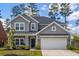 Charming home featuring a two-car garage, covered porch, and beautifully landscaped front yard at 153 Lucca Dr, Summerville, SC 29486