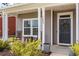 Charming front porch with rocking chairs, decorative wreath, and well-manicured landscaping at 153 Lucca Dr, Summerville, SC 29486