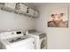 Functional laundry room with modern washer and dryer, overhead storage, and decorative artwork at 153 Lucca Dr, Summerville, SC 29486