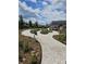 Community garden featuring a stone path, garden beds with flowers and plants, and clubhouse in the background at 154 Helena Park Dr, Summerville, SC 29486