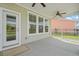 A well-lit screened-in patio with a ceiling fan and a door that leads to the backyard at 154 Helena Park Dr, Summerville, SC 29486