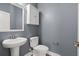 Neutral powder room features a pedestal sink, a toilet, and a white storage cabinet at 154 Helena Park Dr, Summerville, SC 29486